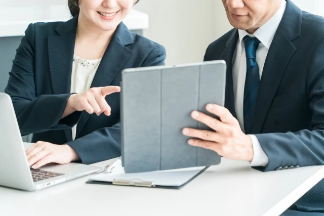 タブレットを見て話す男女