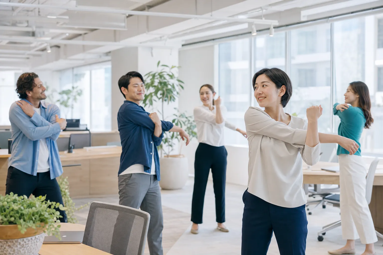 明るいオフィスでストレッチをする従業員